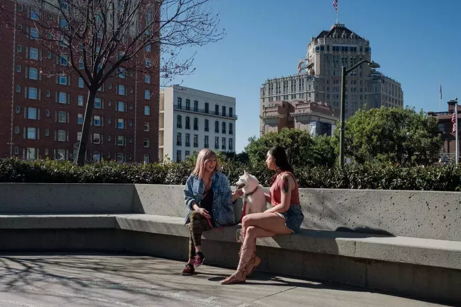 Nya Cruz sitting with a friend and a dog in Nob Hill.